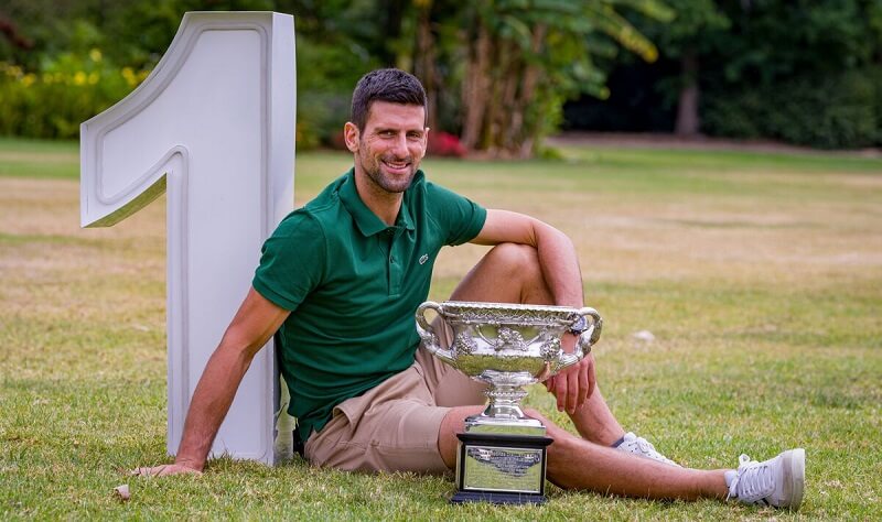 Djokovic bên cạnh biểu tượng số 1 và chức vô địch Australian Open.
